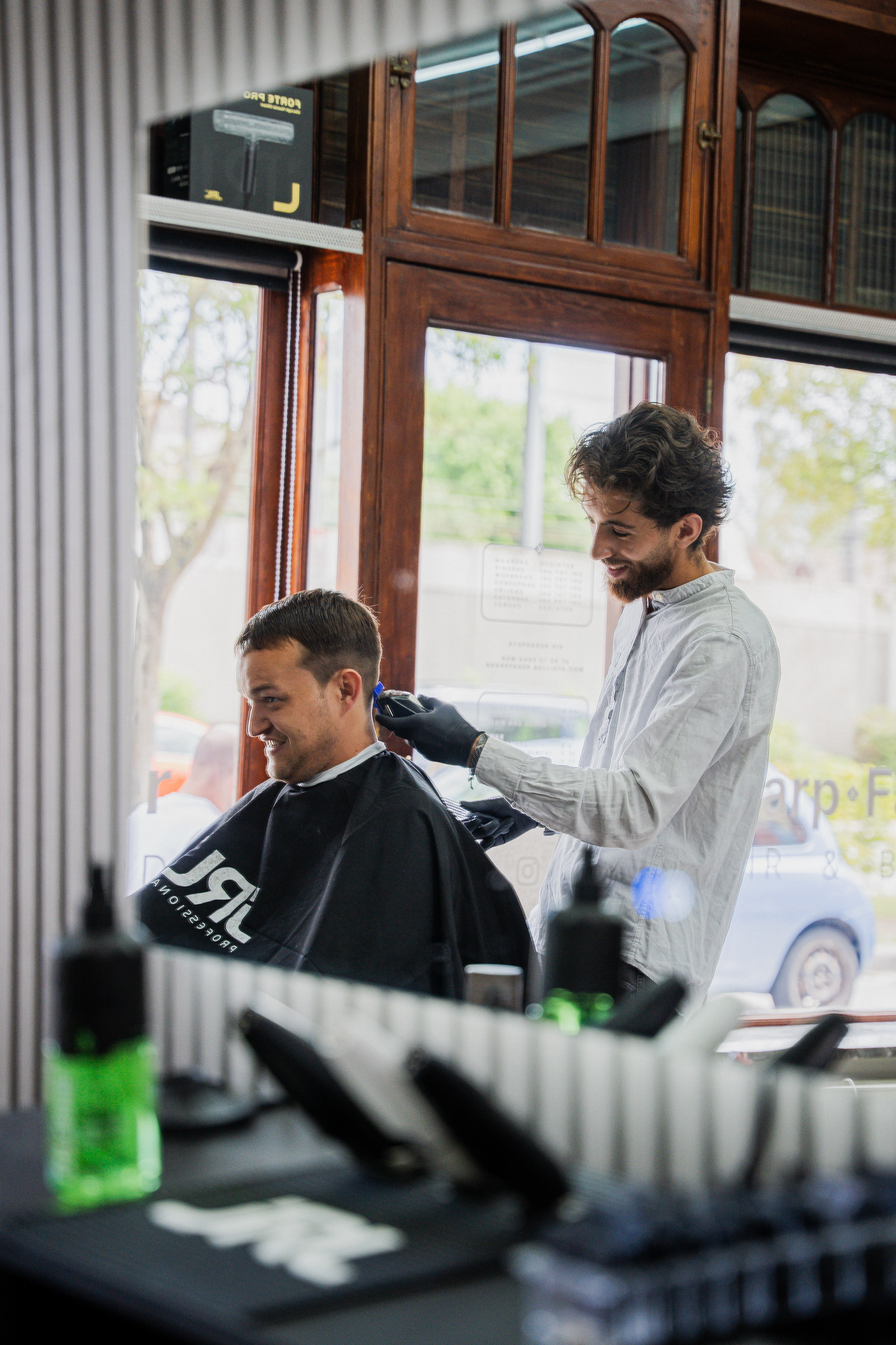 Hasan gebruikt een trimmer voor een fade bij een klant