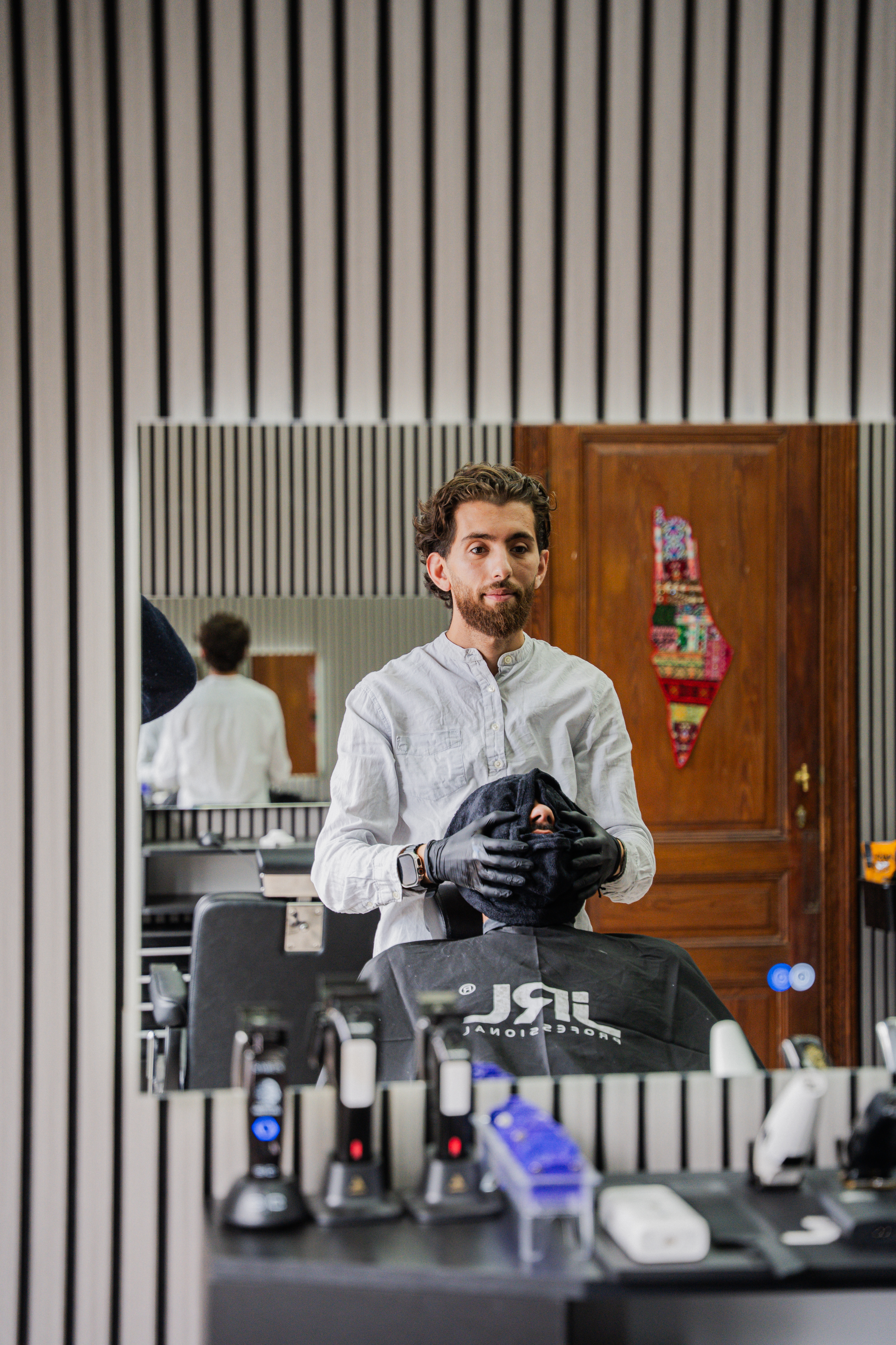 Hasan is bezig met een hot towel behandeling
